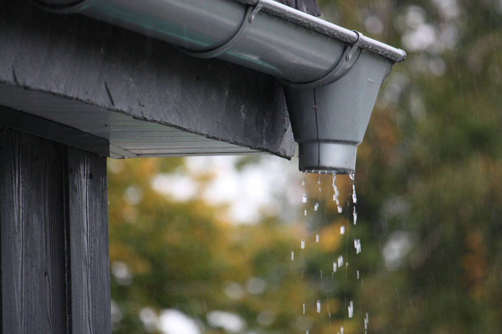 Closeup shot of water drops falling from rain gutters